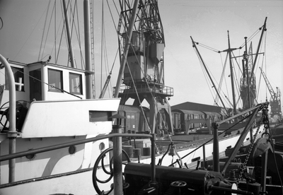 854051 Afbeelding van de overslag van goederen van schip naar spoor op een kade in de haven van Rotterdam.